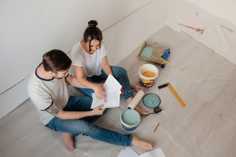 Couple étudiant un dossier immobilier pendant des travaux