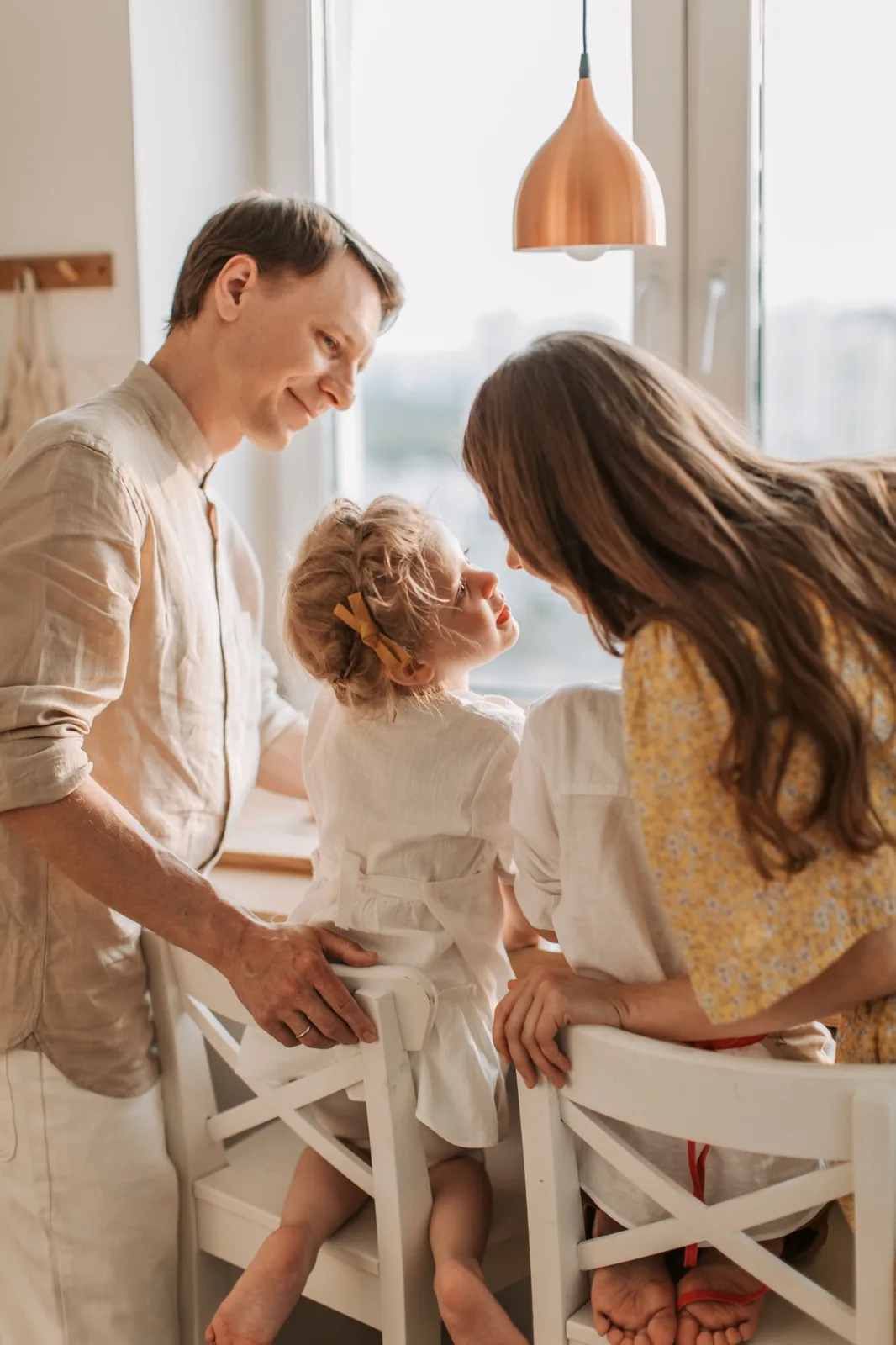 Familia reunida alrededor de una mesa en una cocina luminosa con luz natural