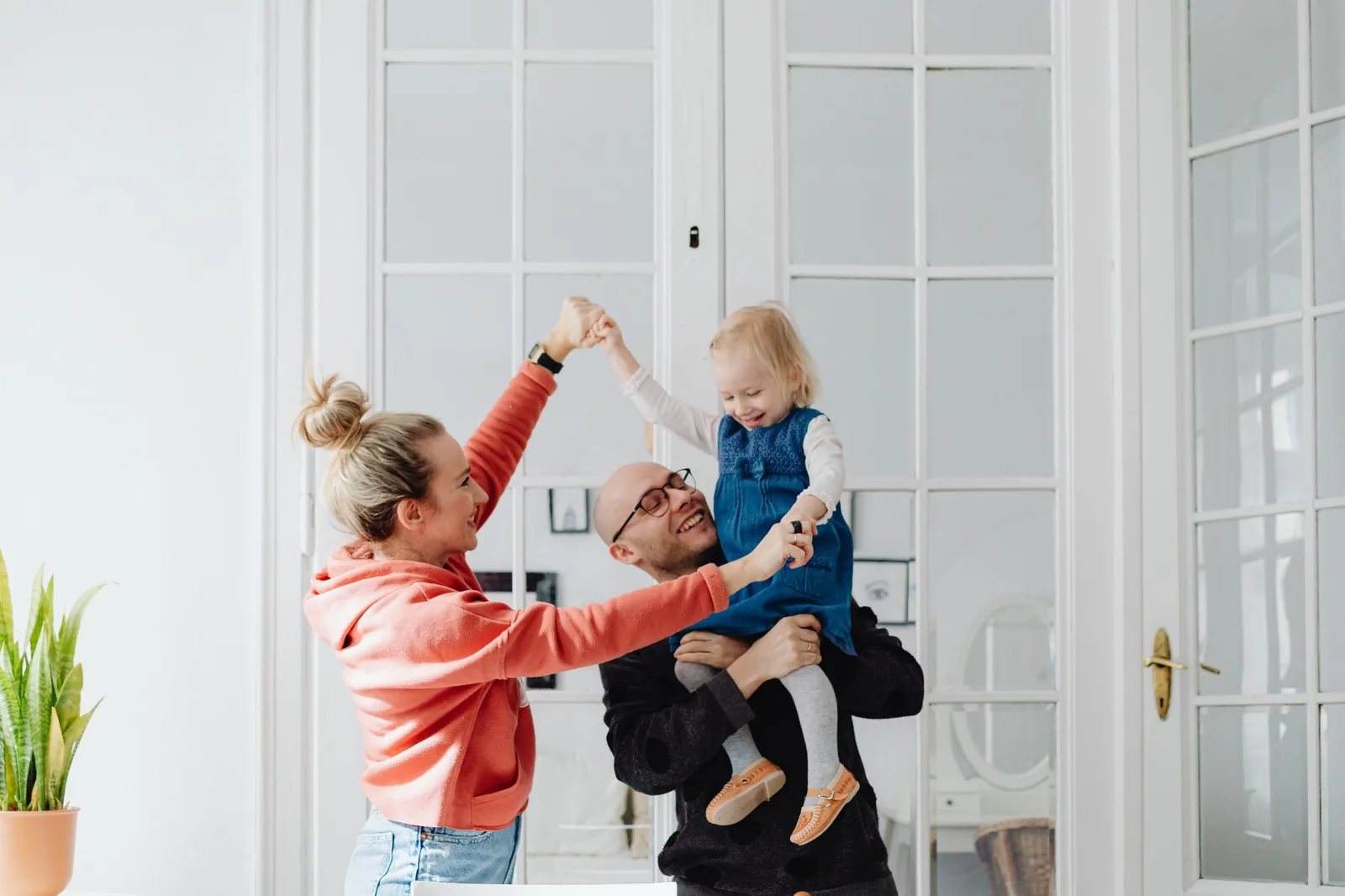 Familia con hijos jugando en una habitación clara y acogedora