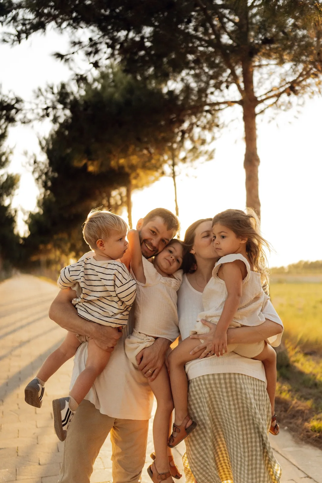 Familia abrazándose al aire libre durante la luz dorada del atardecer