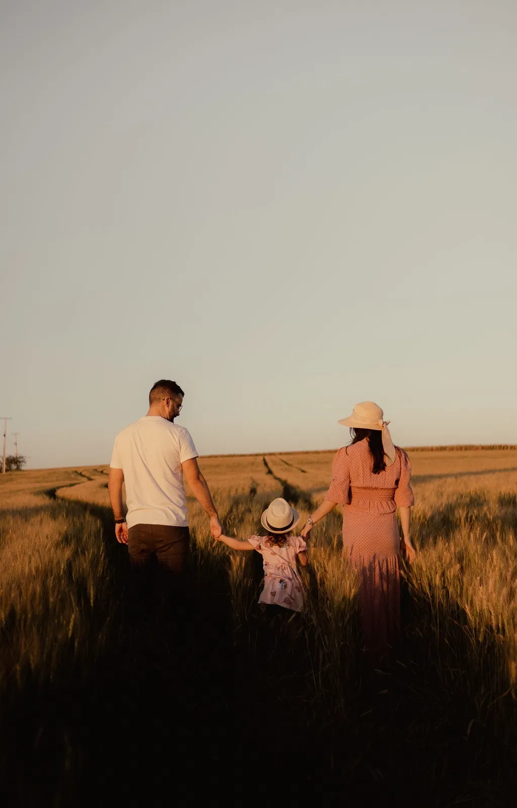 Familia caminando al atardecer en un entorno tranquilo y luminoso