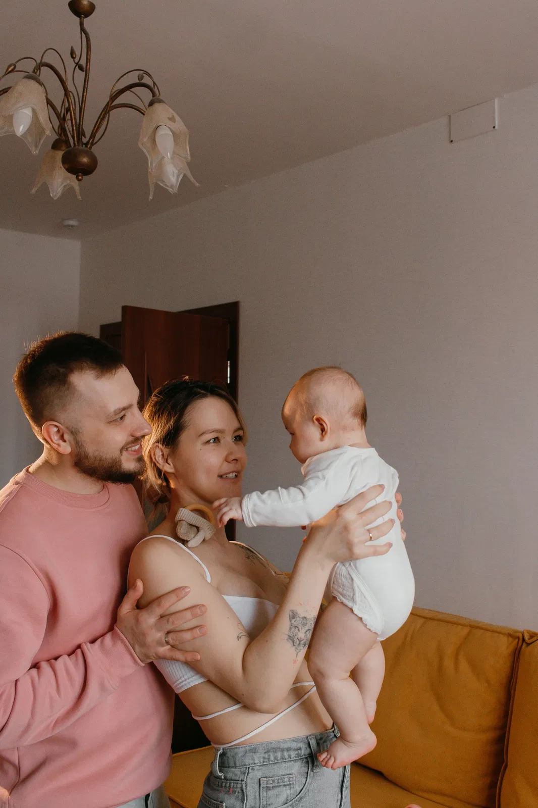 Pareja con su bebé en el salón de su vivienda