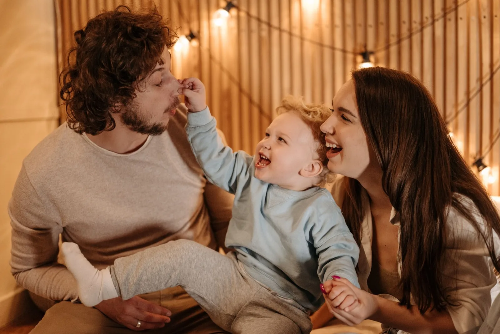 Familia joven riendo y jugando junta en casa
